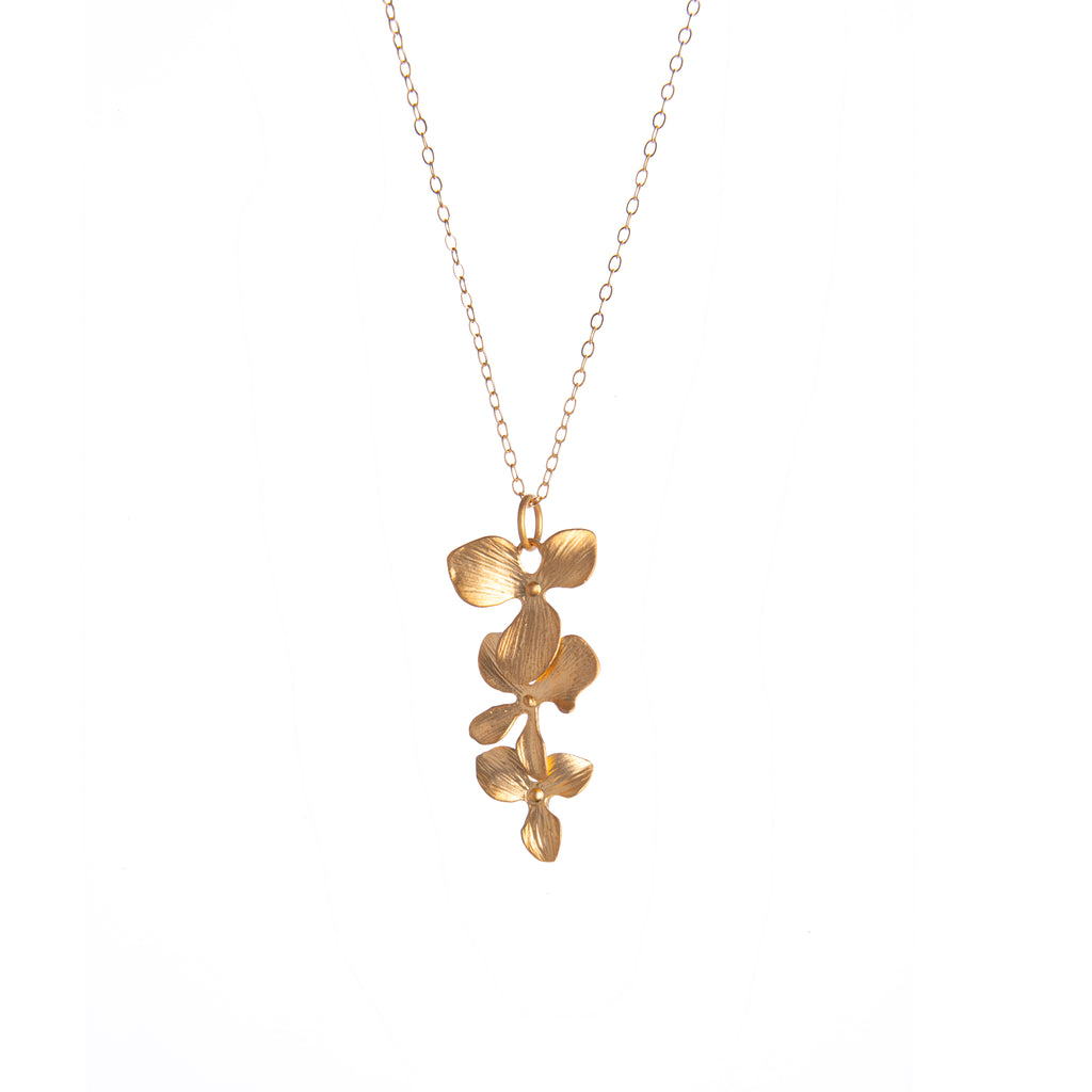 This elegant, stylish, and charming gold-dipped necklace features an organic construction and feminine floral details. Bring the beauty of our gardens with you wherever you go with this beautiful, unique necklace. 14k gold-filled chain 16k matte gold–dipped, carved orchid cascading drop detail.