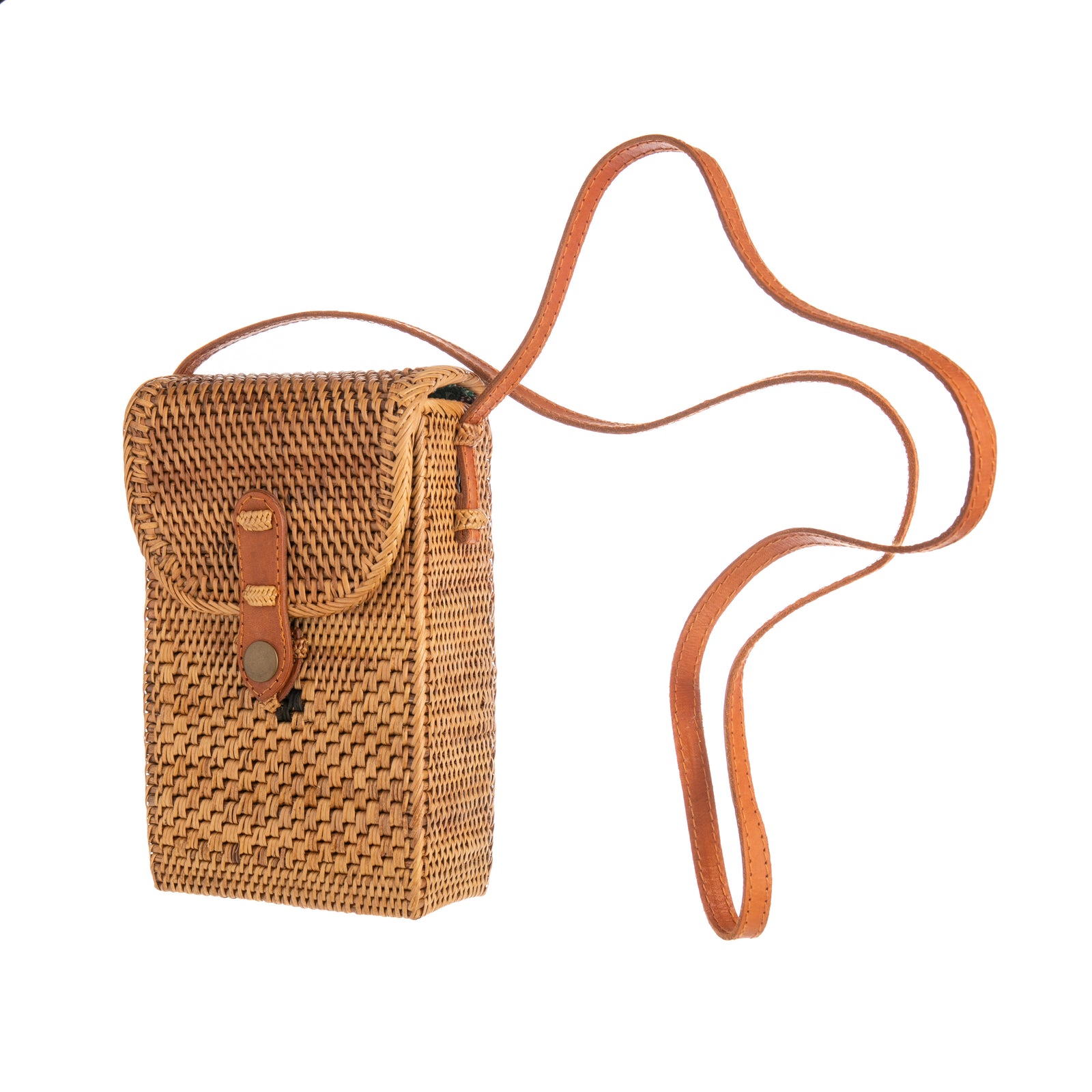 This crossbody purse is hand woven by Balinese women in Eastern Bali. After the bags are woven, they are dried, hung over a fire, which gives them their golden color and makes them hard and durable. Features a leather crossbody strap. Fair Trade production Material: Ata vine, leather strap Dimensions: 7.5" x 5" x 2.5"