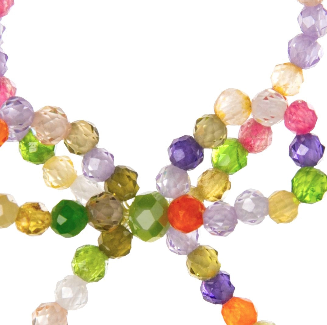 Colorful beaded ring with a bow detail on a white background