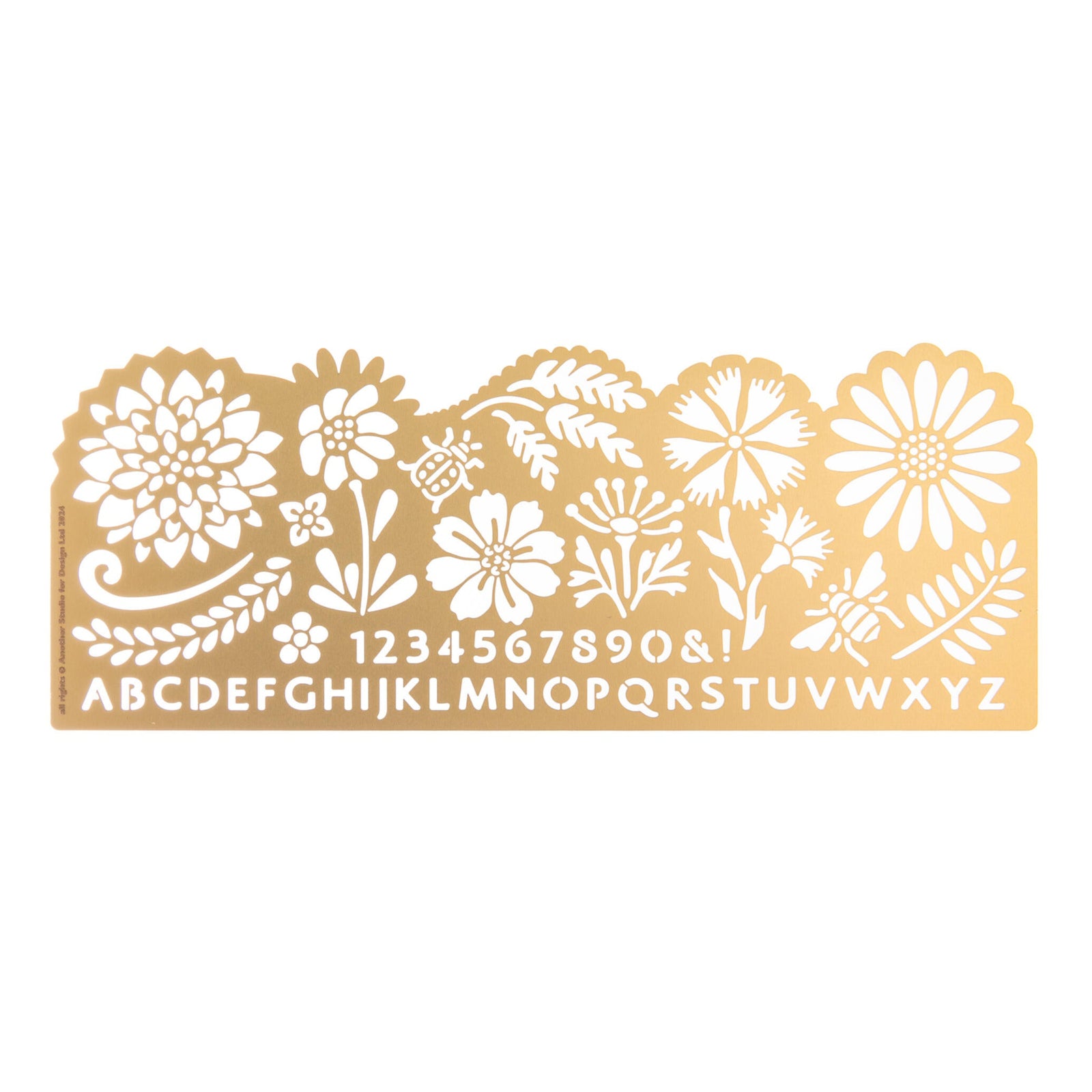 Decorative brass stencil with floral patterns and letters on a white background