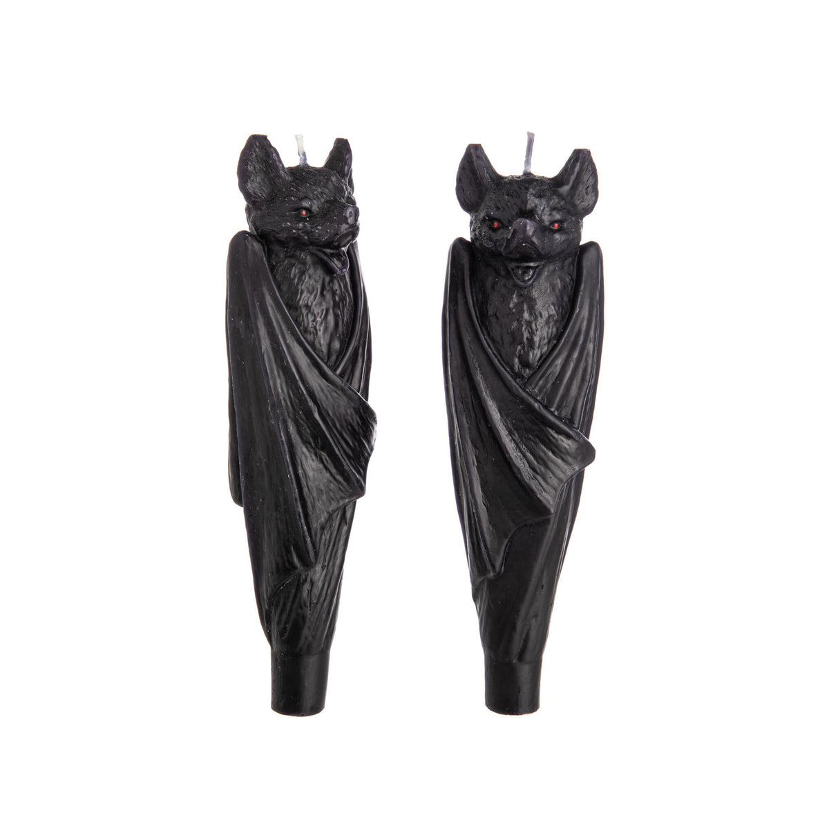 Two black bat-shaped taper candles on a white background