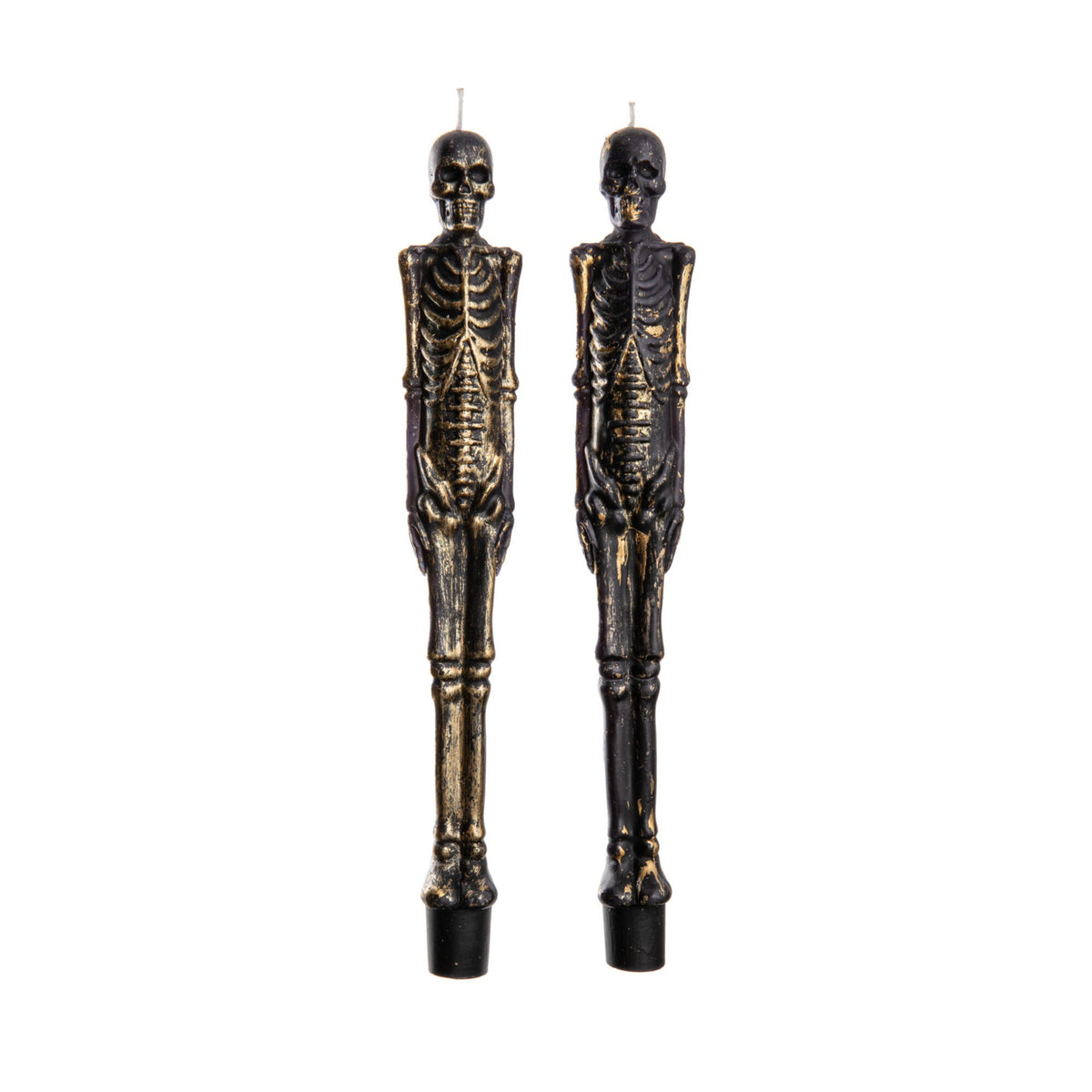 Two skeleton-shaped taper candles on a white background