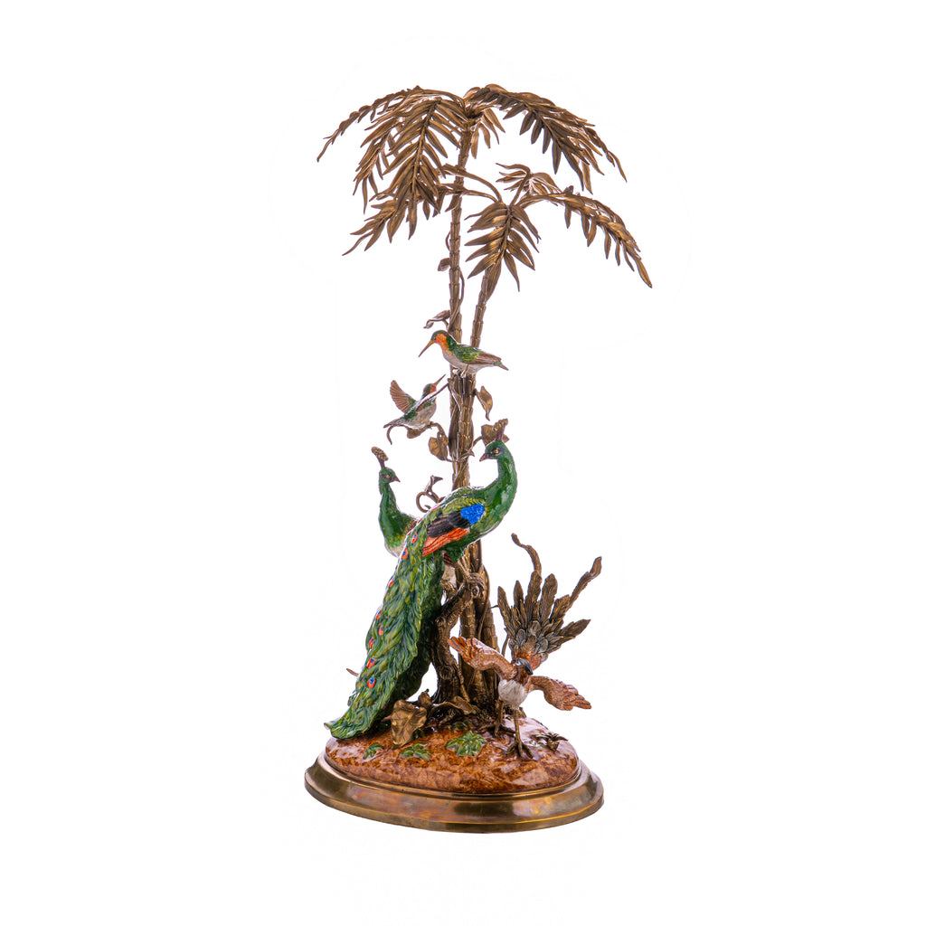 This sculptured centerpiece features hand-painted peacocks and hummingbirds flying within a palm garden. Made of cast bronze and porcelain and, this high quality sculpture is reminiscent of classic art pieces. An elegant piece with sculptural beauty. Dimensions: 19" x 15" x 33" Material: Bronze, Porcelain