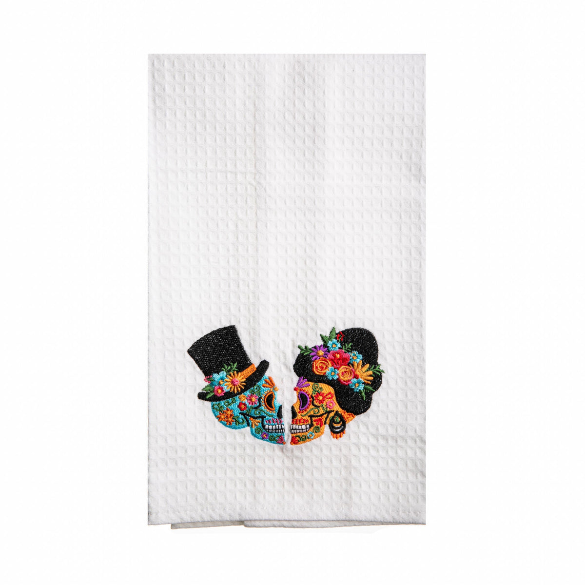 White kitchen towel with colorful skull design and top hats on a white background