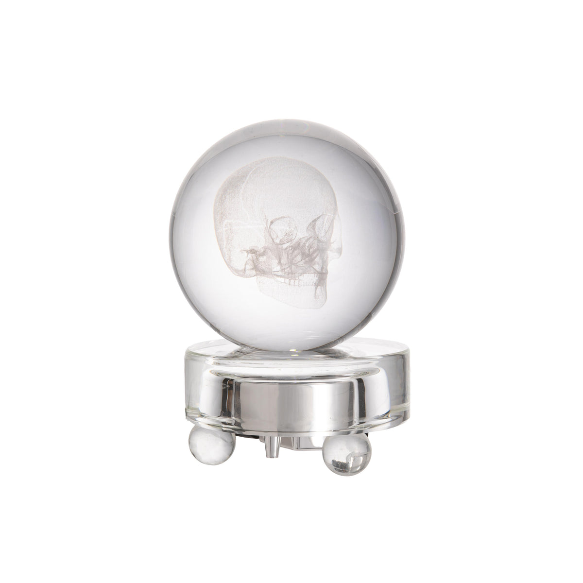 Glass sphere with engraved design of a skull on a crystal glass light-up base against a white background