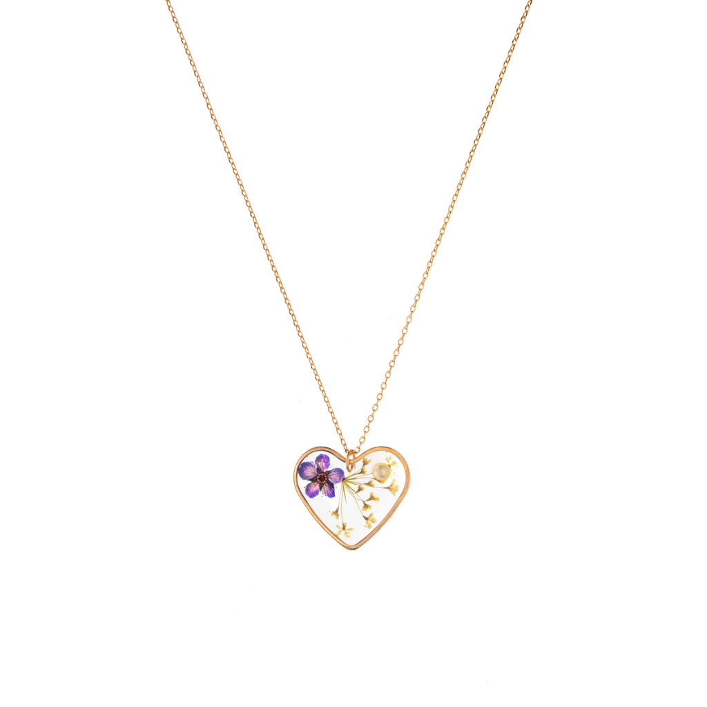  This necklace features a heart-shaped pendant bordered in gold, filled with resin and real flowers pressed inside. A small faux pearl is half-set in the resin to finish off the piece. 14-carat gold-plated brass. 16" to 18" adjustable chain. Pendant: 0.7" width x 0.7" height x 0.2" depth.
