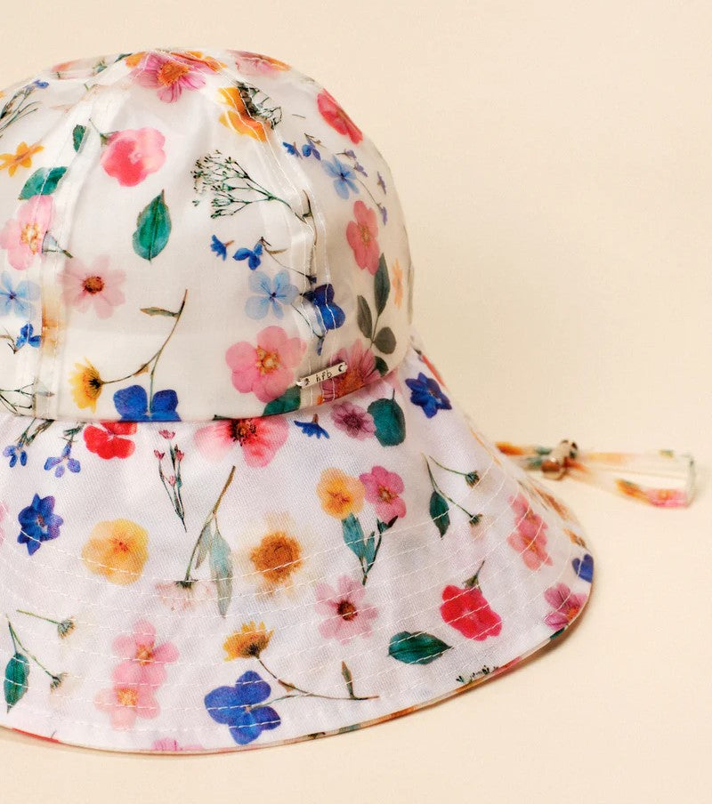 The perfect hat, just in time for spring! Inspired by our passion for gardening, this adjustable bucket style is made of lined water-resistant fabric and covered in bright wildflowers. Perfect for both beach days, and rainy days, and fold up to easily fit into your purse or backpack. One size: Circumference 22" Materials: Cotton, TPU Hand wash / flat dry