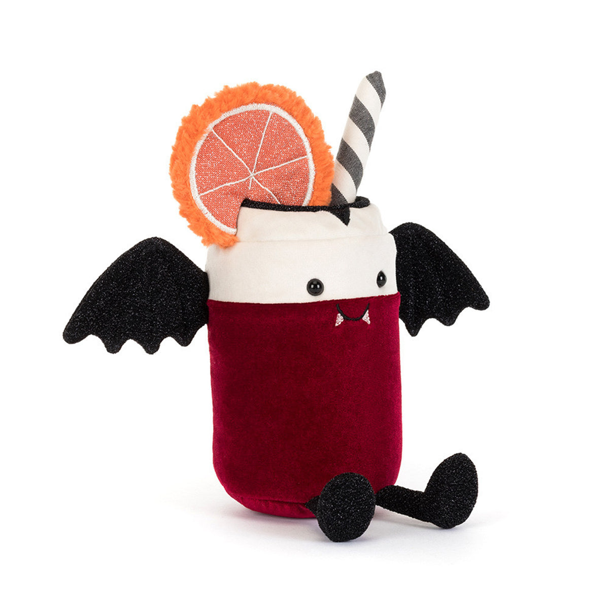 A plush Jellycat toy shaped like a vampire cocktail in a glass, with a deep red body, white rim, black wings, black feet, a striped straw, and an orange slice decoration on a white background.