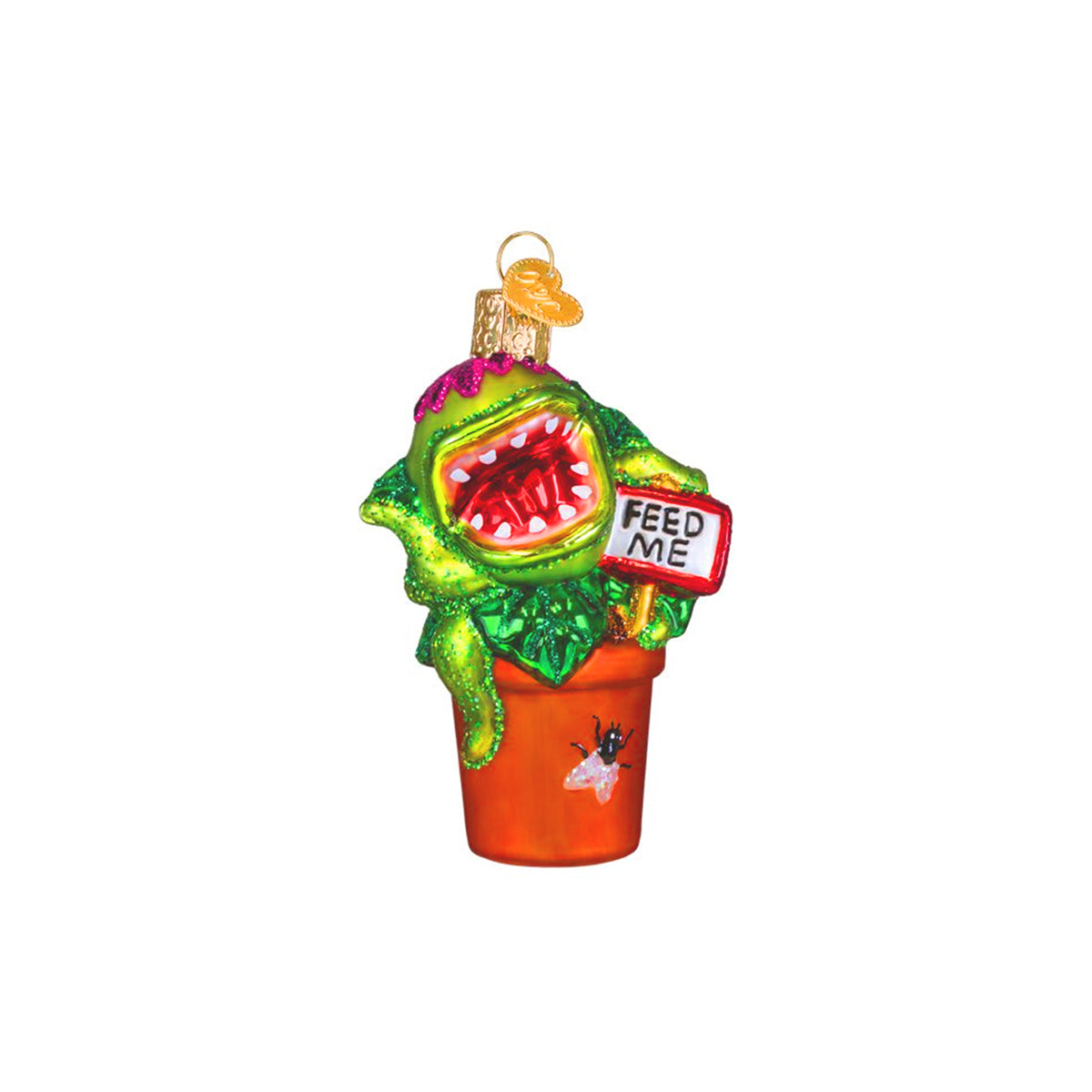 A green Venus Flytrap Christmas ornament shaped like a potted plant with a monster face inside, an orange pot, and a small sign that reads 'FEED ME'.