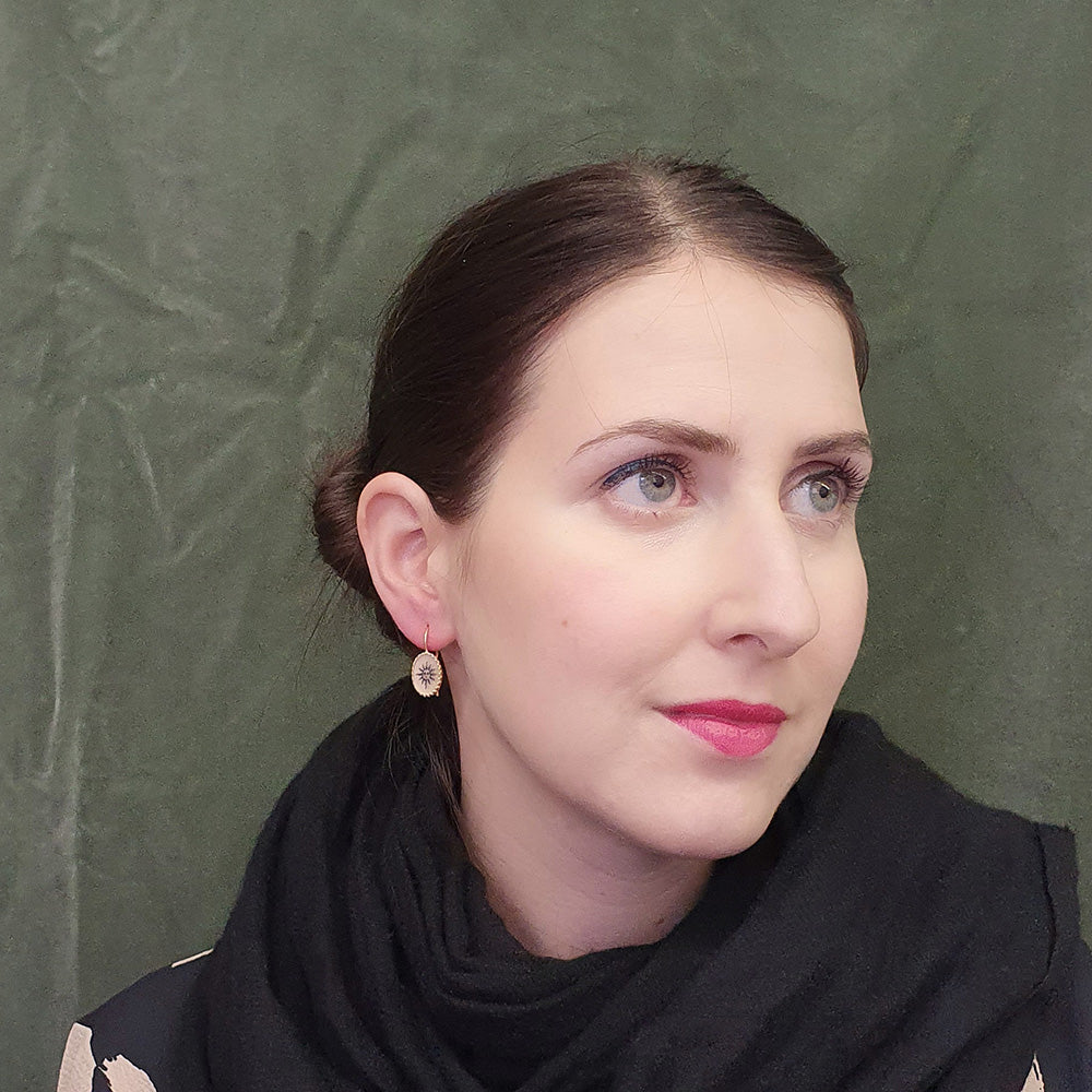 These delicate earrings have a vintage feel and feature hand drawn, Victorian inspired sun and moon artwork set in a scalloped gold vermeil frame. Each pair is individually crafted by hand. Materials: Gold vermeil, resin Handmade with hand-drawn artwork Hook fastening Dimensions: 0.75" x 0.4".