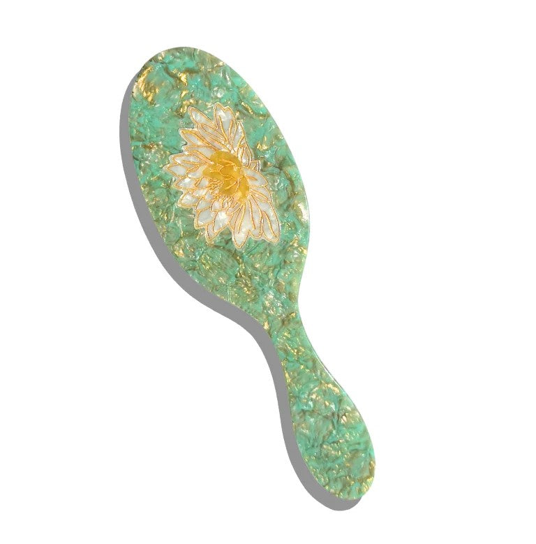 This delightful hairbrush is made of individually cut and formed eco-friendly cellulose acetate, and the waterlily design is individually hand painted with gold metallic accents. This 2-in-1 perfect daily brush is designed for all hair types + textures. featuring two types of bristles, it can be safely used on wet + dry hair.