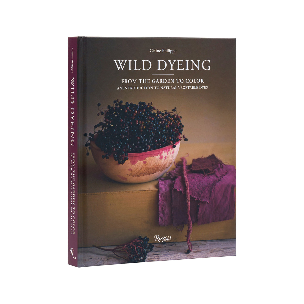 The book 'Wild Dyeing' by Coline Philippe, published by Regu, shown at a three-quarter angle against a plain white background. The cover features a dark brown background with a photograph of a bowl of dark berries and purple fabric, while the spine is a solid deep purple.