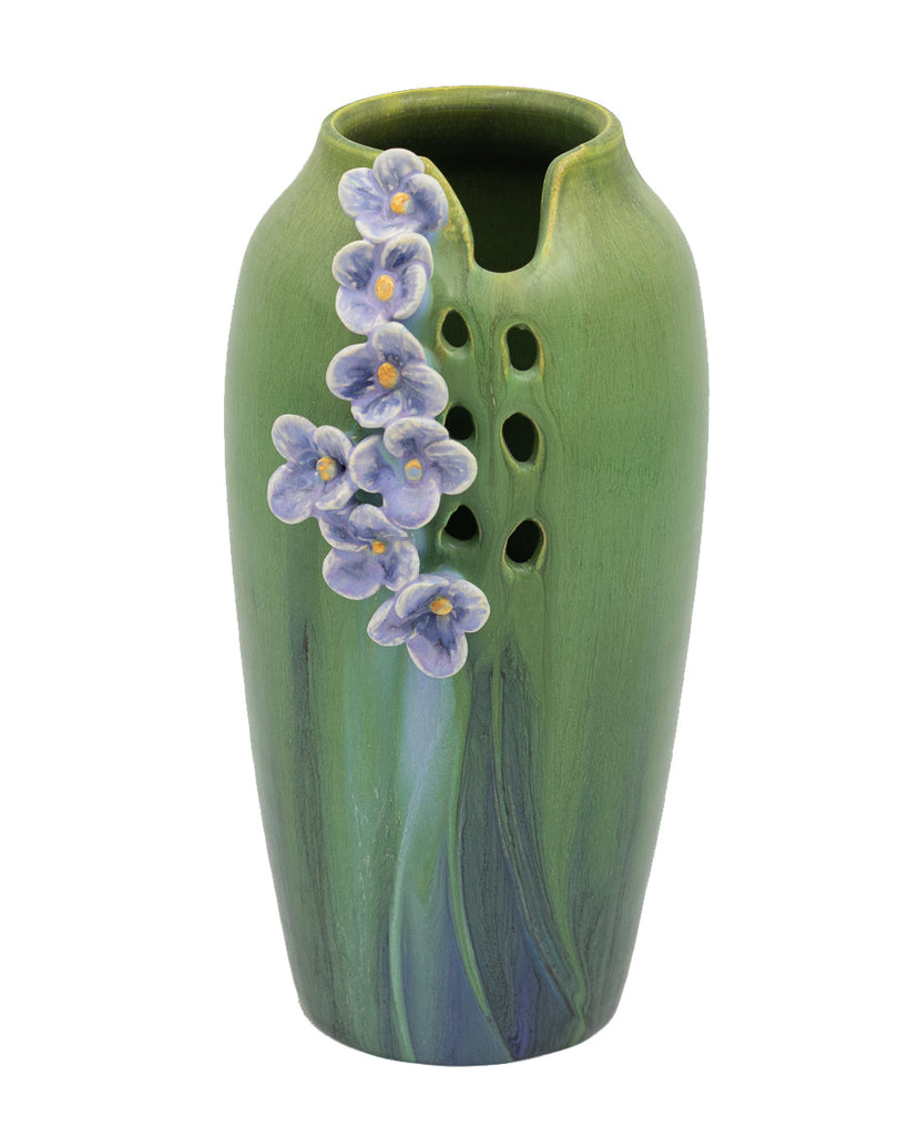 A patch of delicate wildflowers meanders down the face of this slender, petite vase. The beautiful glaze combination of this piece has a rich, complex surface quality. 100% Handmade.  7.25″H x 4.25″W Traditional earthenware art pottery is porous, glass liner recommended for use with water.