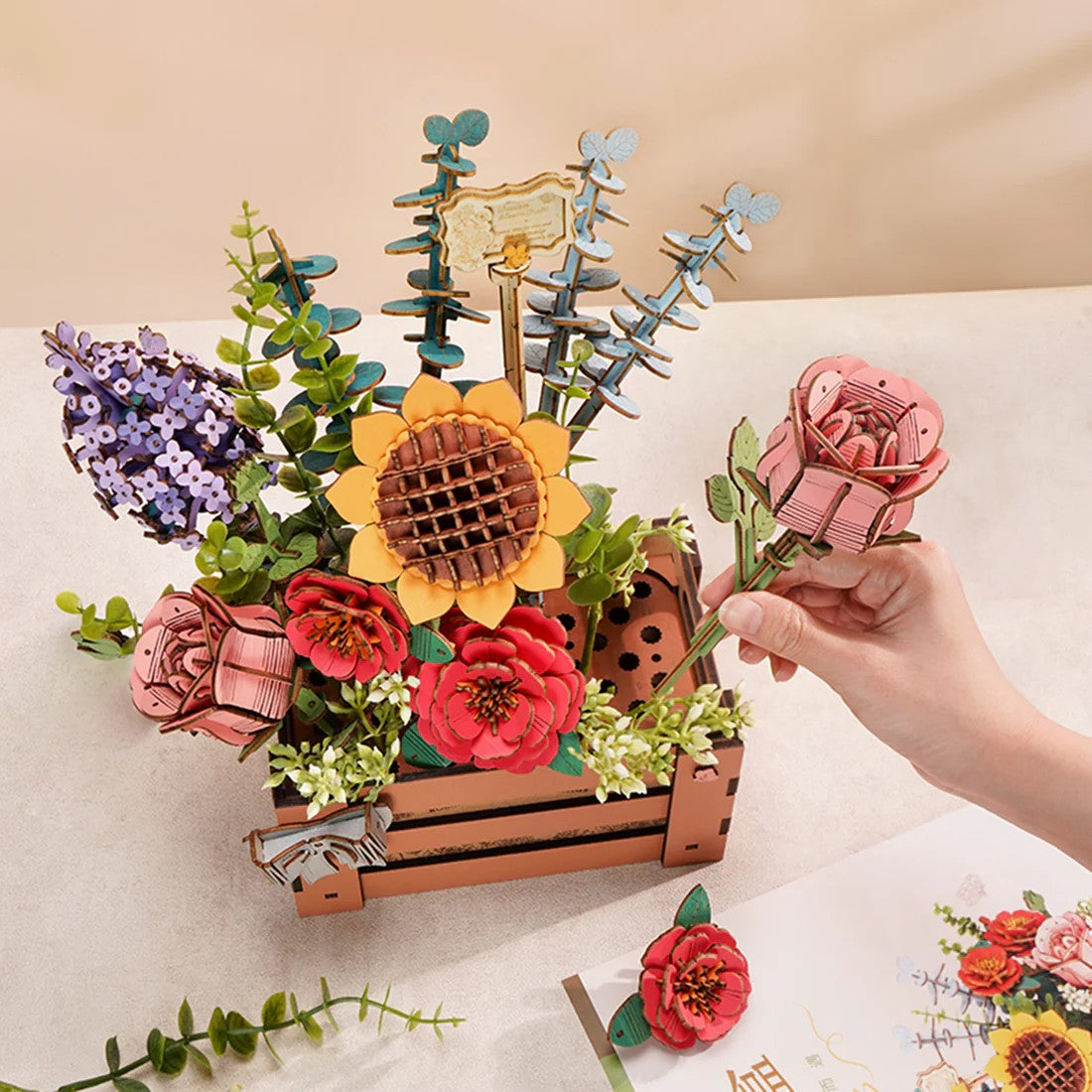 Decorative flower arrangement in a wooden crate on a white background