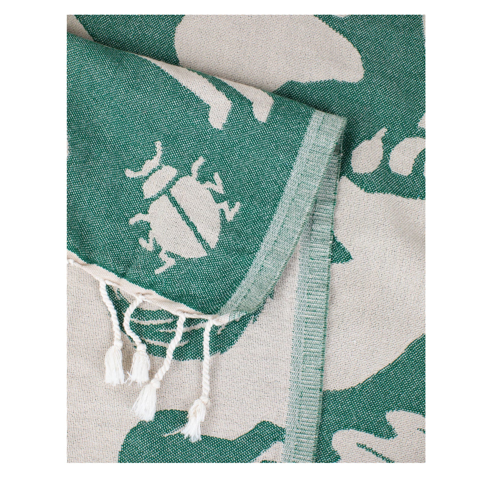 Beige towel with green forest animal and plant pattern on a white background