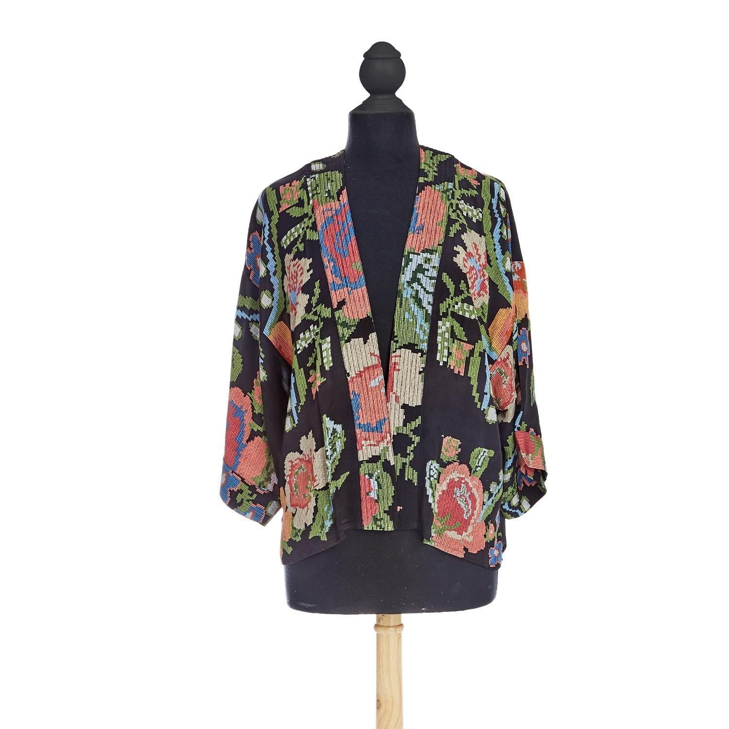 Colorful patterned jacket on a mannequin against a white background