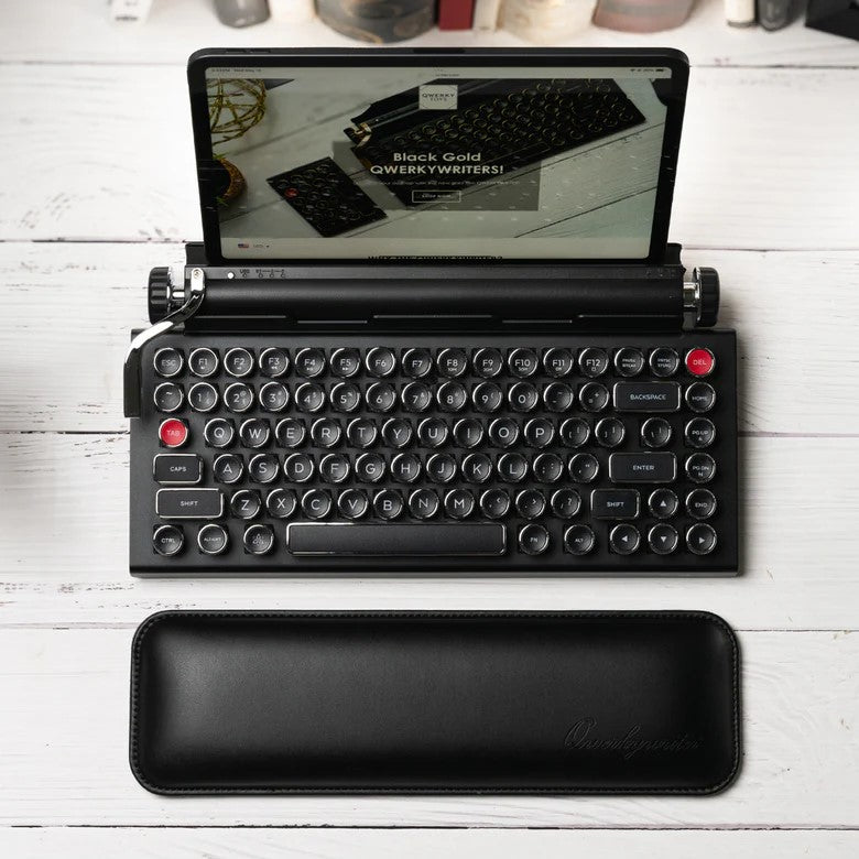 Black rectangular computer mouse wrist rest with 'Qwerkywriter' branding on a white background