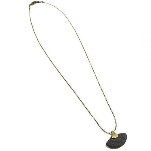 This contemporary jewelry piece is handmade using Binchotan, or Japanese wood charcoal. This exceptional natural material has been used in Japanese arts and crafts for centuries and is used here to create unique and stunning jewelry pieces. This pendant necklace features polished charcoal in the shape of a ginkgo leaf, trimmed with antique brass.