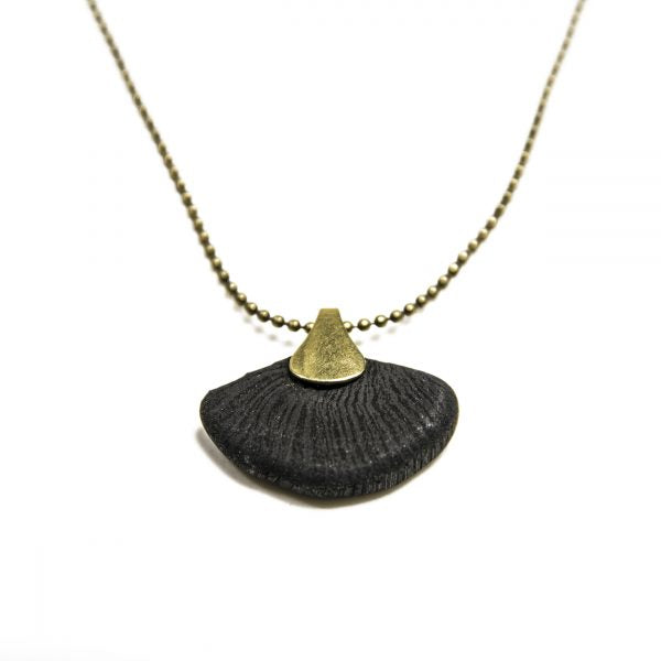 This contemporary jewelry piece is handmade using Binchotan, or Japanese wood charcoal. This exceptional natural material has been used in Japanese arts and crafts for centuries and is used here to create unique and stunning jewelry pieces. This pendant necklace features polished charcoal in the shape of a ginkgo leaf, trimmed with antique brass.