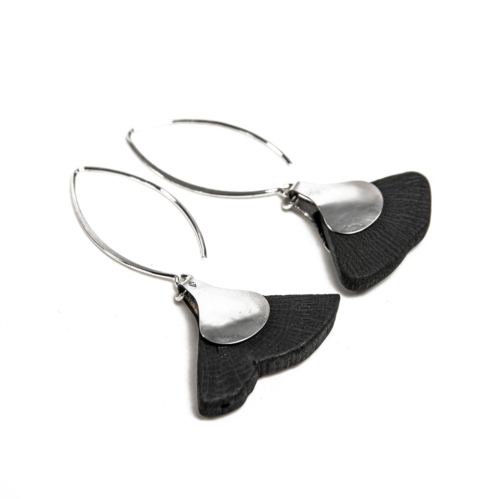 These earrings are handmade using Binchotan, or Japanese wood charcoal. This exceptional natural material has been used in Japanese arts and crafts for centuries, and here, it is used to create unique and stunning jewelry pieces. These exquisite earrings feature polished charcoal in the shape of a ginkgo leaf, trimmed with 925 silver. 