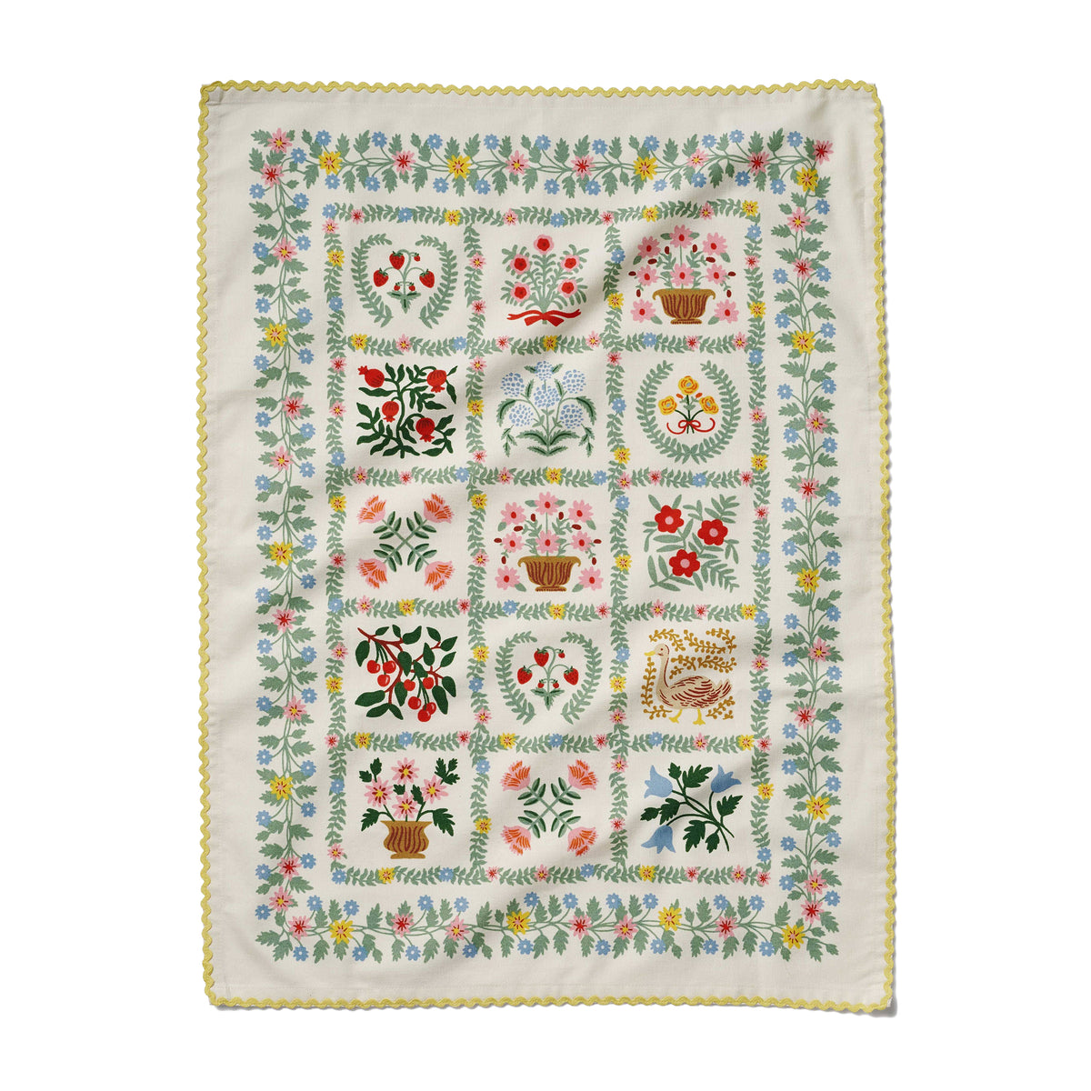 Embroidered quilt with floral and geometric patterns on a white background