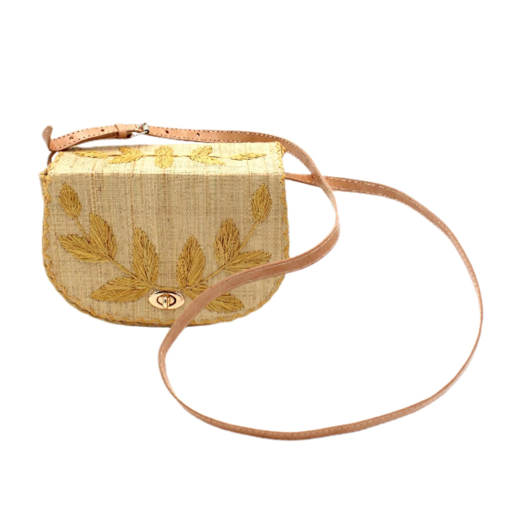 This stylish crossbody bag pays homage to the 1970's with its embroidered leaf design on the front flap and top. The intricate crosshatch detailing adds a retro touch. Crafted from loomed raffia, the bag also features a fabric-lined interior with a convenient internal pocket. A sturdy structure and adjustable leather strap make it a practical option, while the turn lock closure adds a chic finish