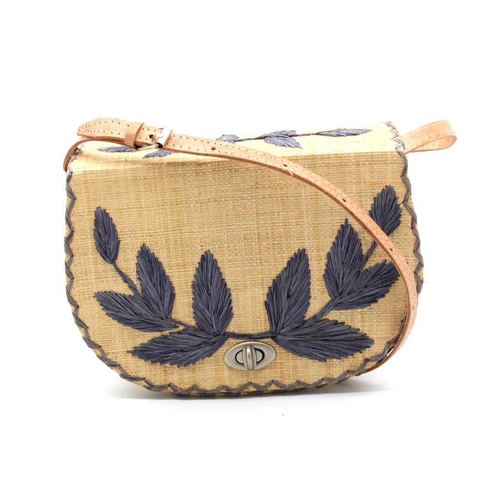 This stylish crossbody bag pays homage to the 1970's with its embroidered leaf design on the front flap and top. The intricate crosshatch detailing adds a retro touch. Crafted from loomed raffia, the bag also features a fabric-lined interior with a convenient internal pocket. A sturdy structure and adjustable leather strap make it a practical option, while the turn lock closure adds a chic finish