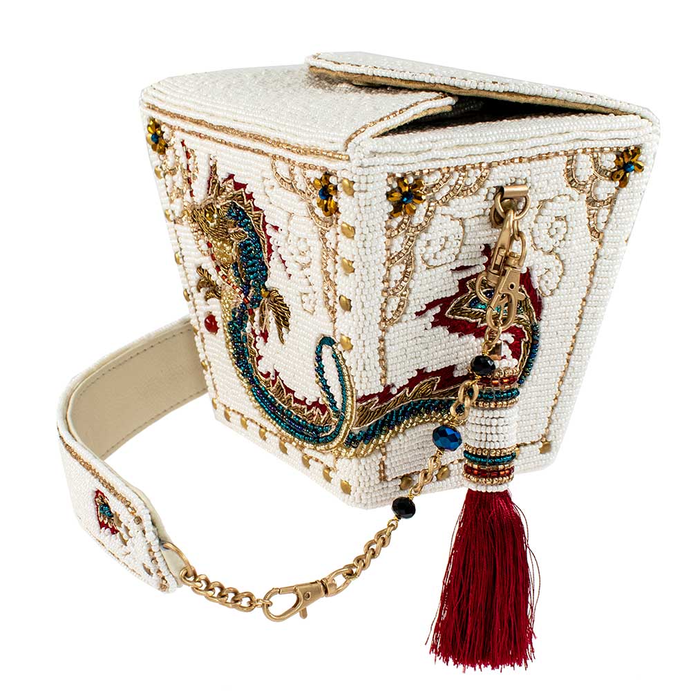 Inspired by the iconic Chinese food takeout container, this unique accessory features an intricate embellished dragon motif with elegant, embroidered detailing, making it a captivating blend of ancient traditions and modern fashion. Dimensions: 6" x 4.75" x 5".  Strap length 15".