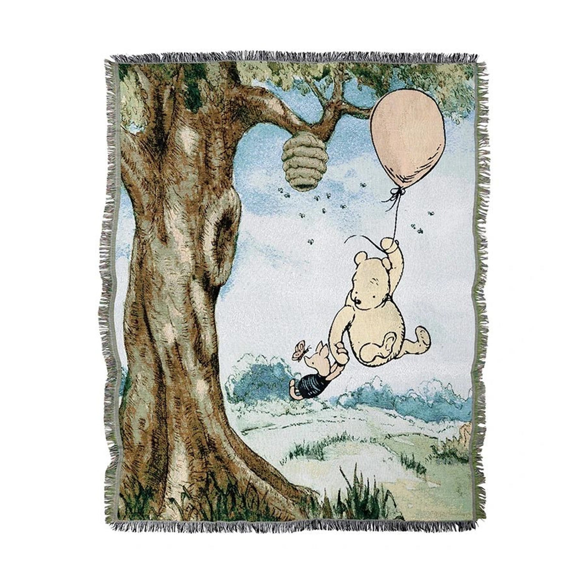 A woven throw blanket featuring a classic Winnie the Pooh illustration, including Pooh hanging from a tree with a balloon and a honeycomb, shown on a white background.