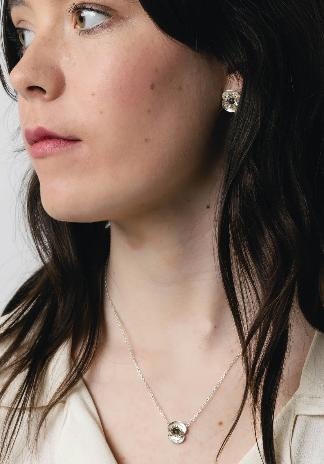 Silver necklace with a floral poppy pendant on a white background