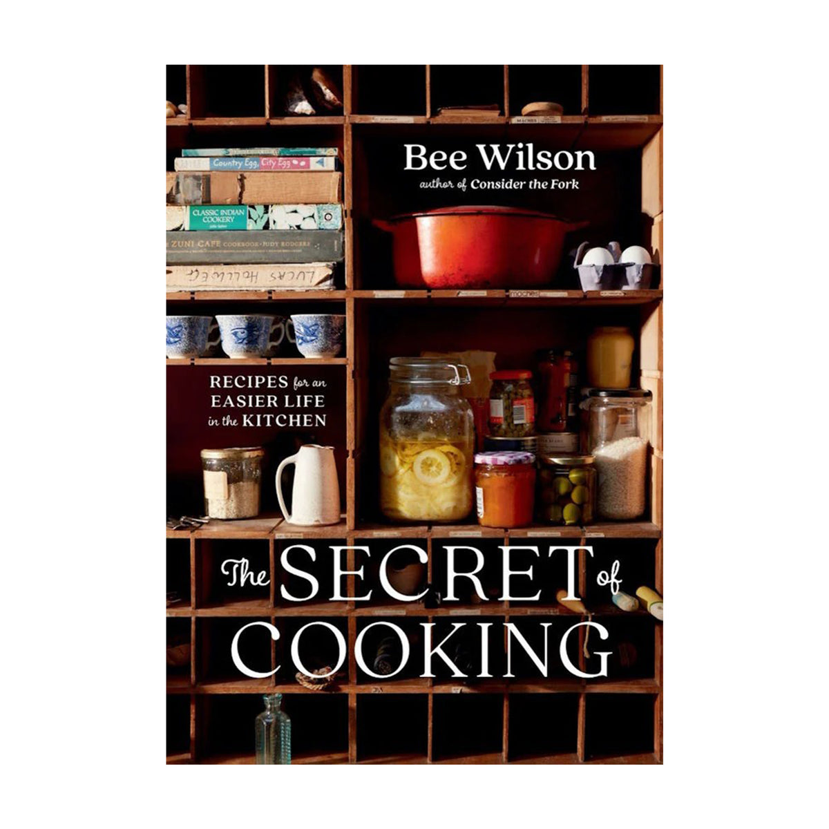 Book cover of 'The Secret of Cooking' by Bee Wilson with a kitchen-themed design.