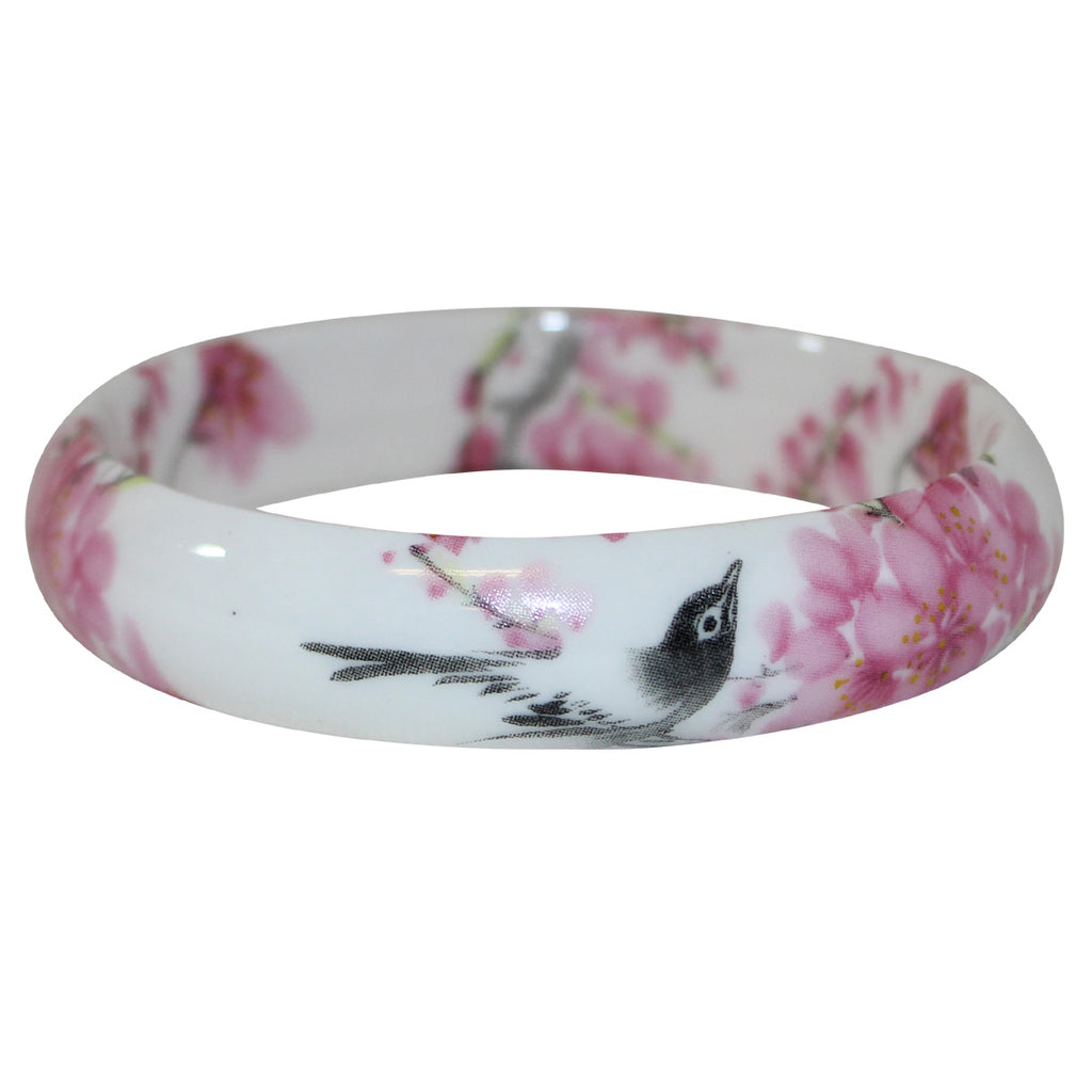 The Cherry, or Sakura tree is representative of good fortune and new beginnings. When the Sakura spirits release their gorgeous fragrance in springtime, their gift of beauty and elegance is celebrated. High-quality, porcelain bangle, decorated with delicate cherry blossoms and a curious bird. One size. Diameter:3".