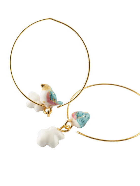 These super pretty, lightweight hoop earrings feature a bluebird and pear blossom flower on a fine gold hoop. Made from durable porcelain and 24K gold plated brass. The porcelain elements are individually painted by hand, making each pair unique. Metal certified nickel free and allergy free. Hoop diameter: 1.4".