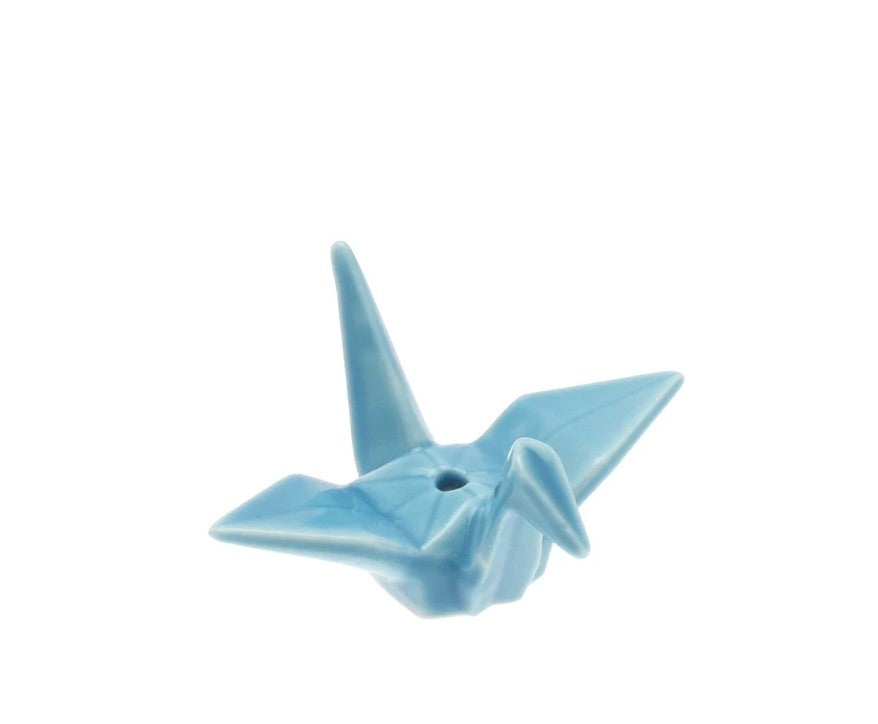 The crane's tall stance and powerful flight pattern make it the perfect symbol of power and strength, representing good fortune and longevity. Bring good fortune into your home with this ceramic origami crane, which is perfectly poised to hold your incense sticks. Ceramic with a sky-blue glaze. Size: 2.5" x 1.25" x 2".