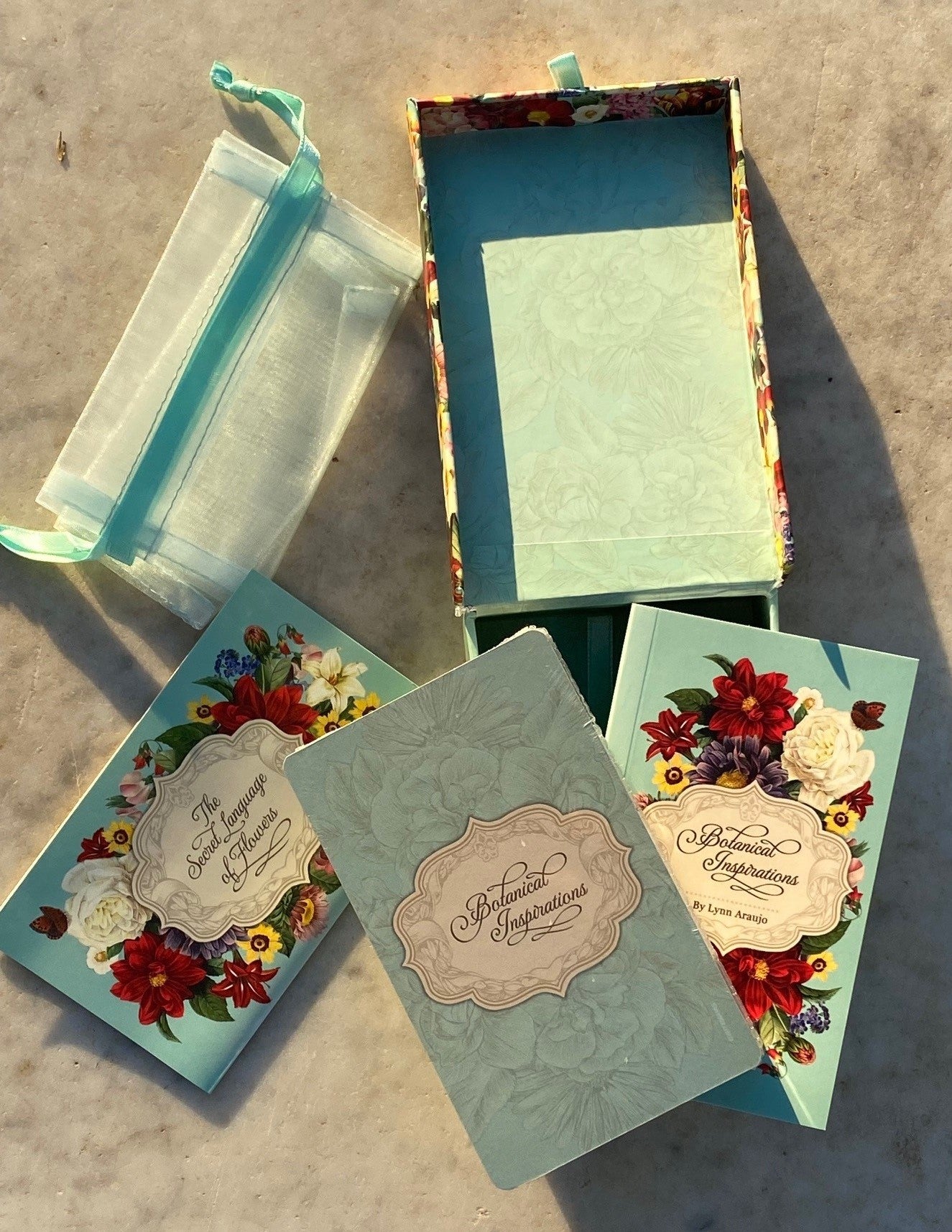 This beautiful, Botanical Inspirations boxed deck features the secret meanings and messages of flowers with the treasured artwork of Pierre-Joseph Redouté. 44 cards with quotations. 100 page illustrated guidebook. Drawstring organza pouch. Packaged in a keepsake box : 5" x 3" x 1.5".