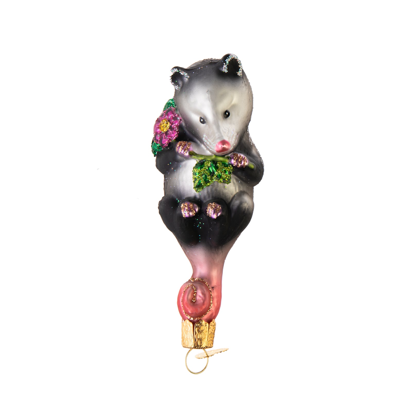 This adorable creature is hardly playing possum as she snuggles a beautiful blossom. Opossums are unique for using their tail as a fifth limb as they climb, hang and balance, hence why this cute Opossum ornament hangs upside down! Glass Ornament Hand painted and glittered Approx 4.25" x1.5"
