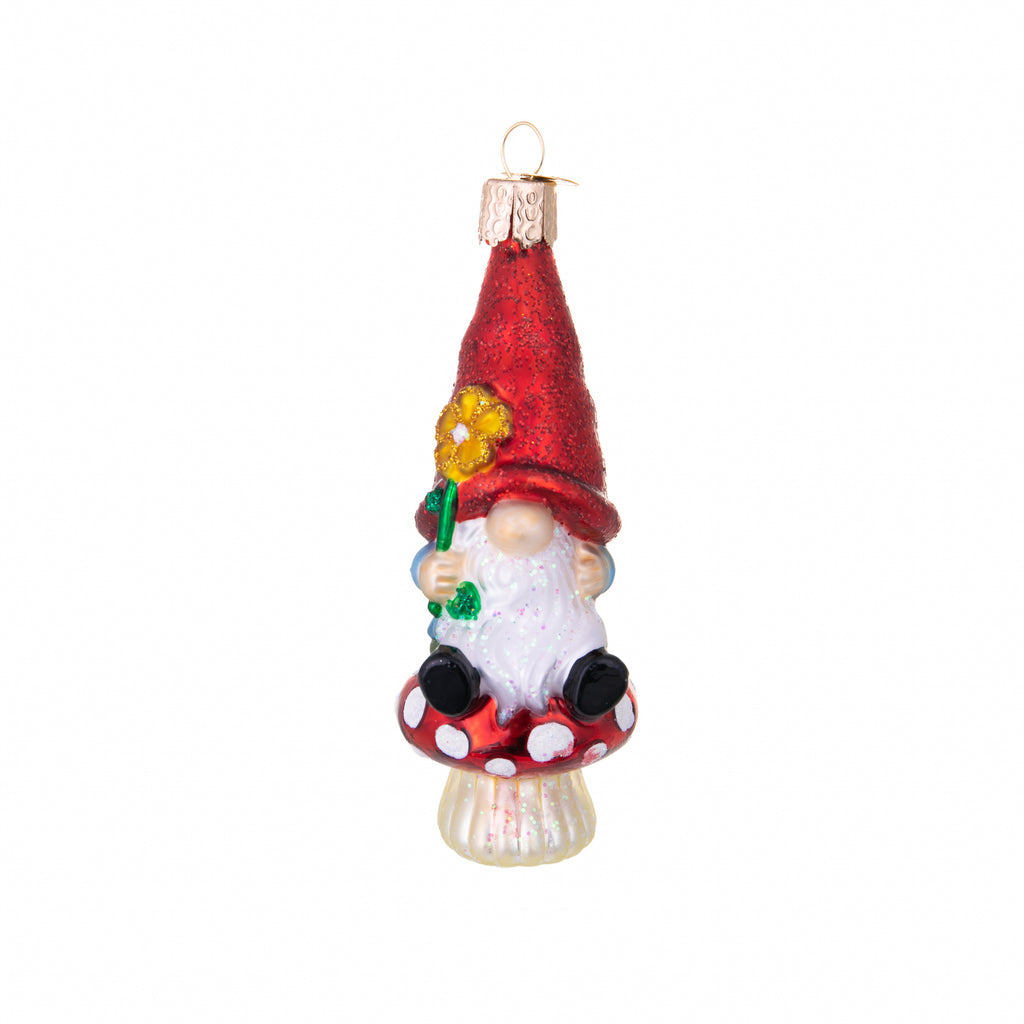 Here's a Gnome that needs a home! Add a magical touch to your holiday decor with this garden gnome ornament. Perched atop a shiny red toadstool, this beardy beauty is the perfect ornament for gardening enthusiasts. Glass ornament Hand painted and glittered Size approx 4" x 1.5"