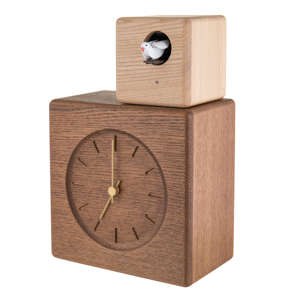 Designed by Gabriel Tan Inspired by postmodern architecture, this cuckoo clock consists of two stacked volumes, made from solid Japanese ash wood. The larger cube contains the clock body and a smaller cube houses the cuckoo, which can be rotated to face different directions.. 7.3 W x 10.8 H x 4.1 D inches. 