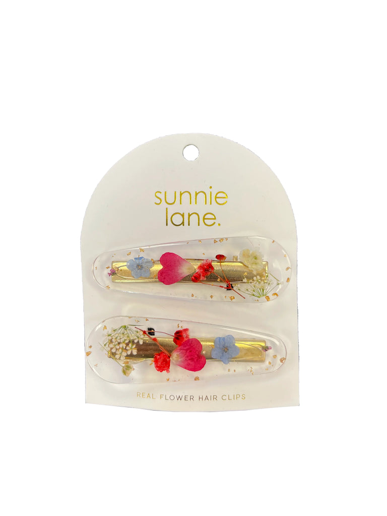 Here's a way to pin flowers into your hair without having to worry about them wilting! These hair clips contain real pressed flowers, encased in resin. Set of two clips 2.5" long Materials: pressed flowers, resin, zinc alloy. Since each flower is unique, each hair clip is unique and may differ slightly from the photo.