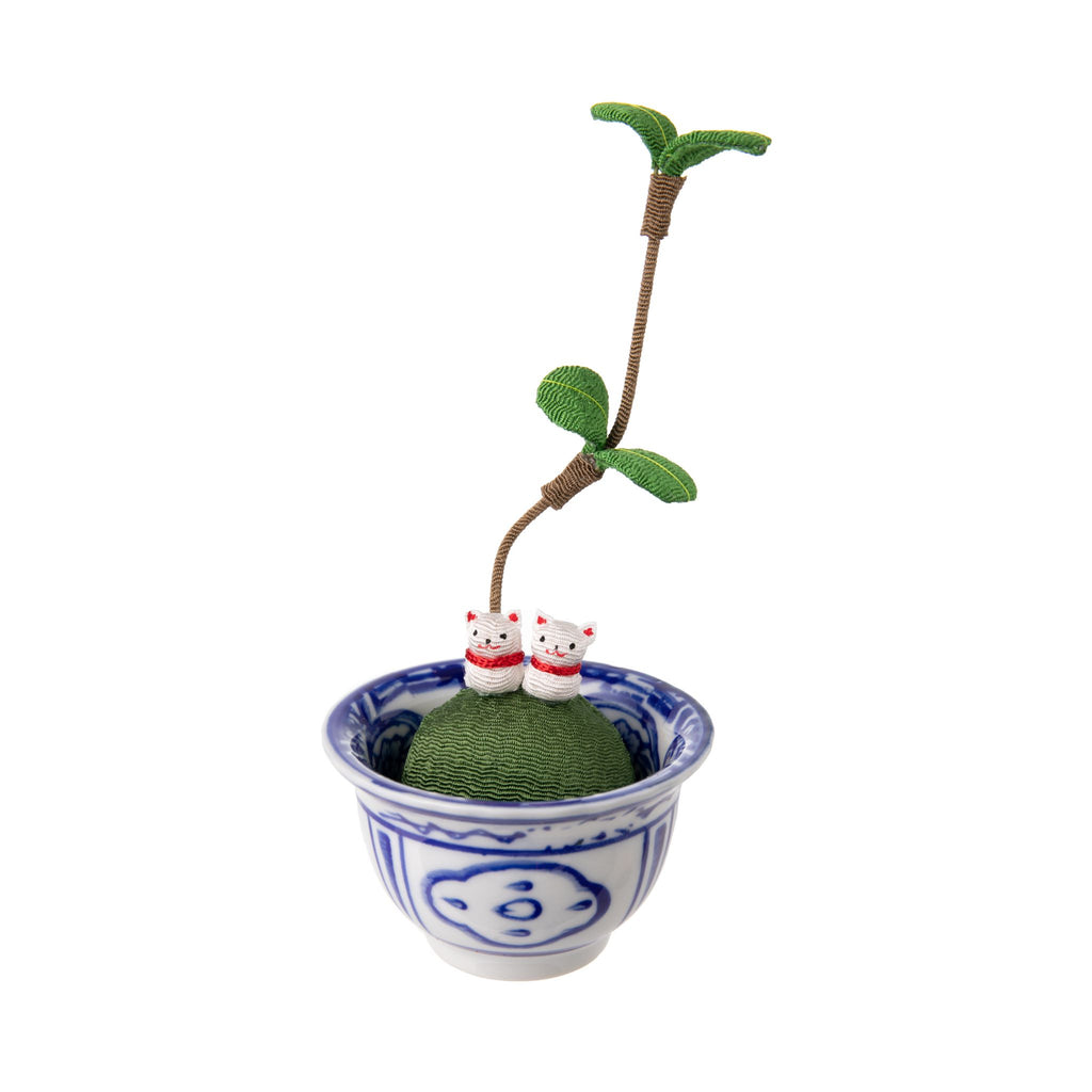 A traditional Japanese lucky charm. Made from chirimen fabric - traditional Japanese crepe silk which is commonly used to make Kimonos. This figure depicts two kittens sitting on a kokedama moss ball, which has freshly sprouted! The kokedama sits in a  blue and white china bowl. Made in Japan Size approx 5" x 2.