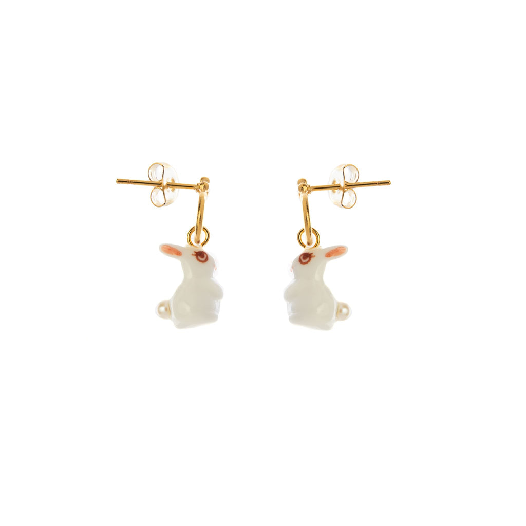 Hop into the year of the rabbit with these adorable earrings. These porcelain bunnies have hand-painted fluttering eyelashes and a tiny pearl tail. Porcelain and 24K gold plated brass earrings - post fastening. Nickel and allergy free. Hand painted - each pair is unique Size: 3/4" x 1/4". Matching necklace available.