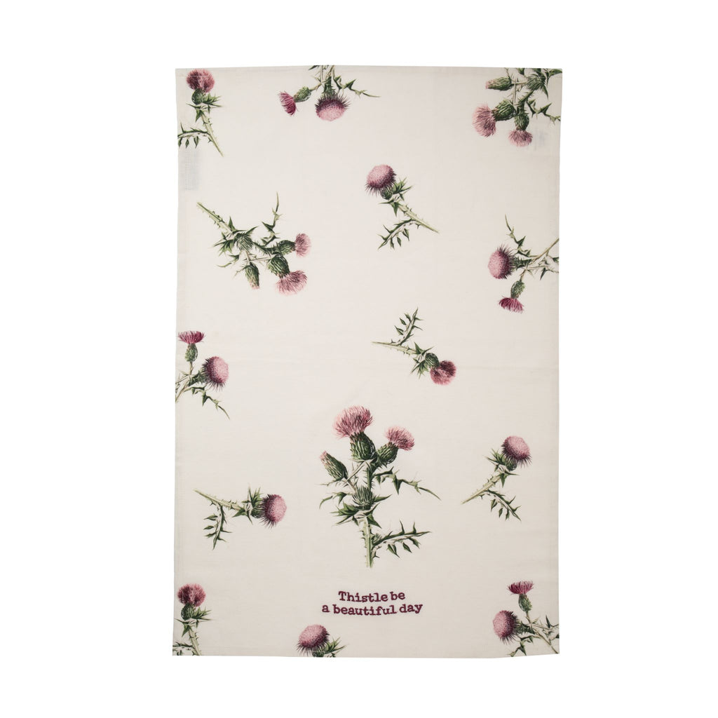 A cotton linen blend kitchen towel featuring all-over vintage style thistle design, embroidered with the playful pun, "Thistle be a beautiful day". Features a cotton tape loop in the corner for easy hanging. Machine-washable. 70% cotton, 30% linen Size: 19" x 28".