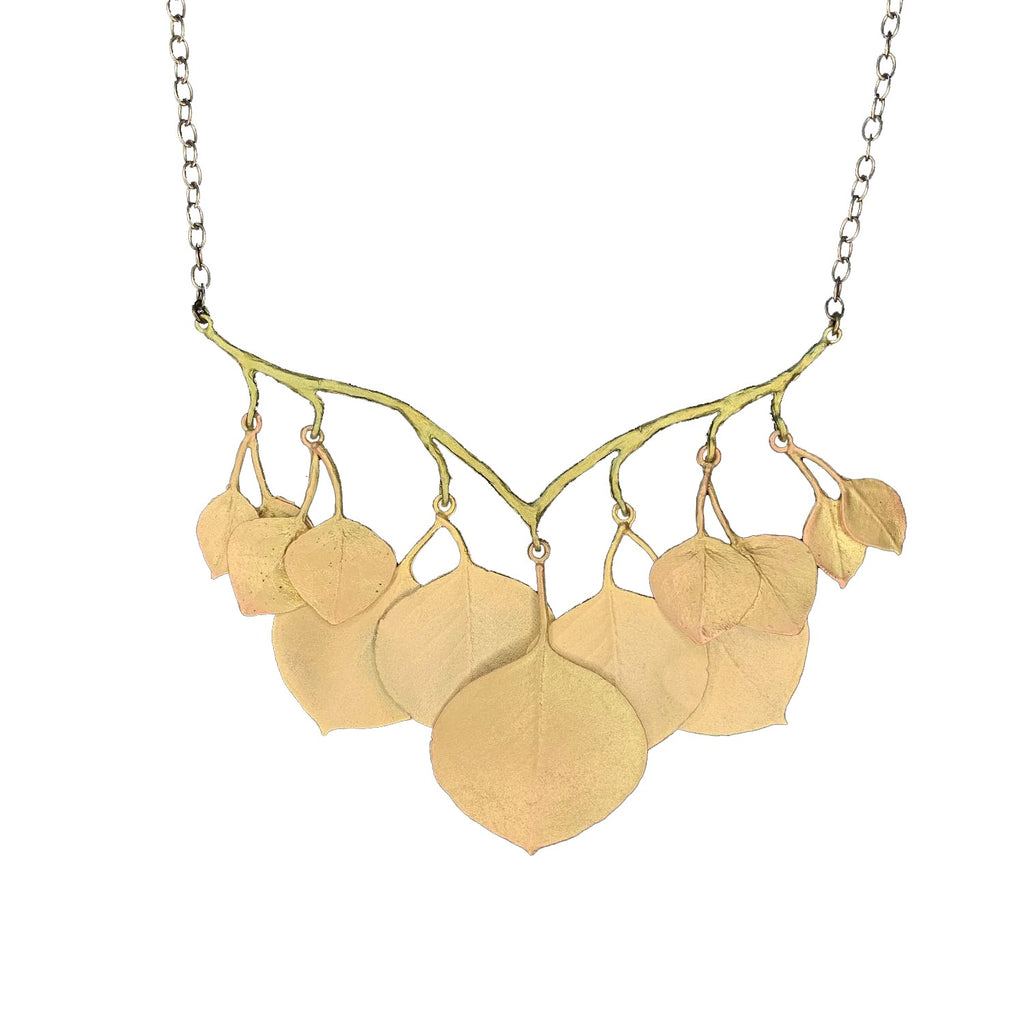 This eucalyptus necklace is cast in bronze with 24kt gold plated leaves and hand patinated branches. A number of leaves also feature soft copper highlights. Measures: 17" - 19" L (adjustable); Branch: 2.98" L x 3.43" W Hand made in the USA by Michael Michaud.